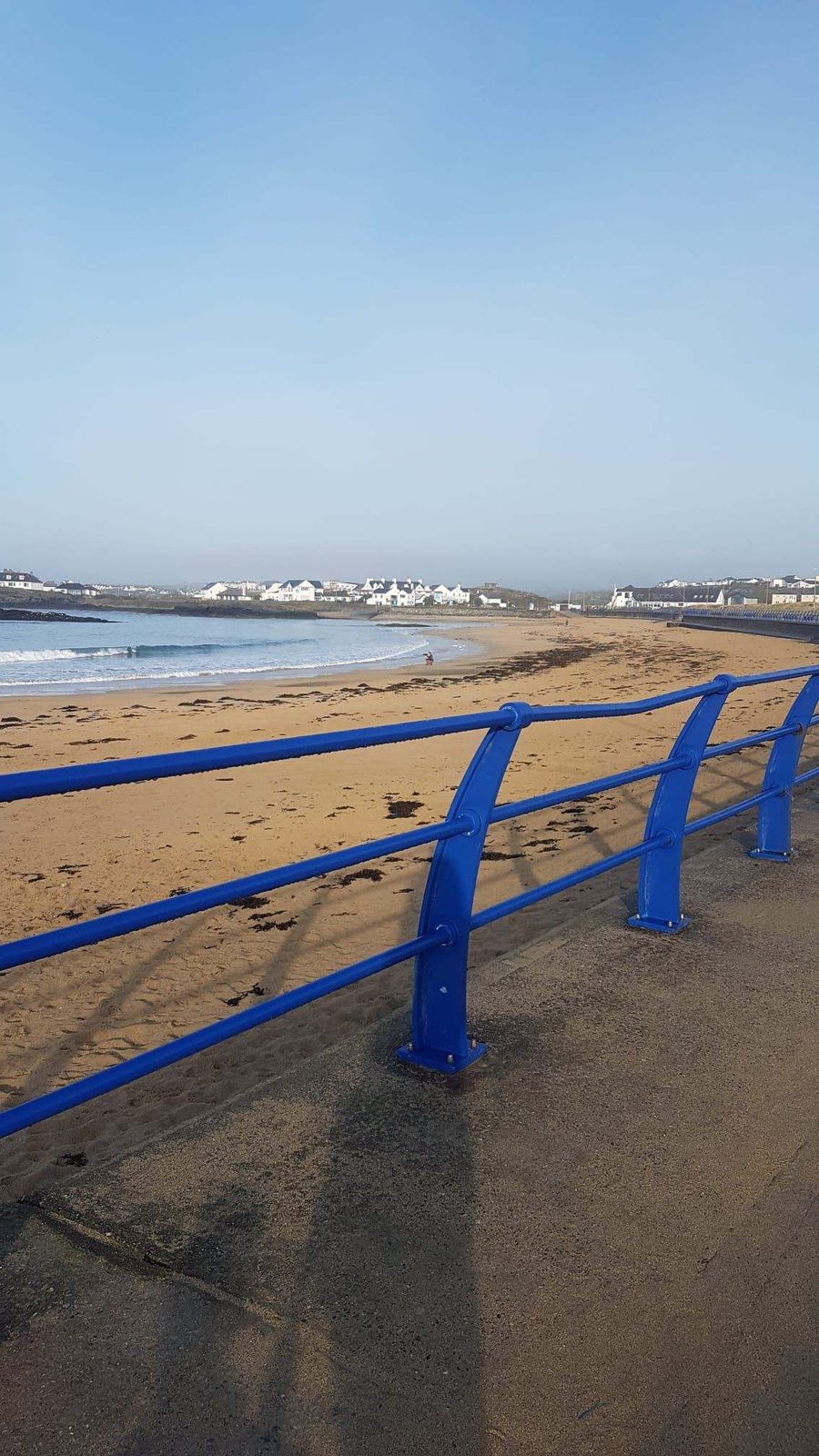 Blue promenade railing by the beach in Holyhead, Anglesey